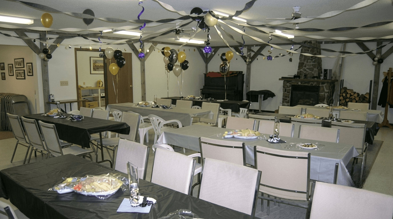 event-hall-setup-with-tables-and-balloons Event hall with tables, chairs, balloons, and ceiling streamers.