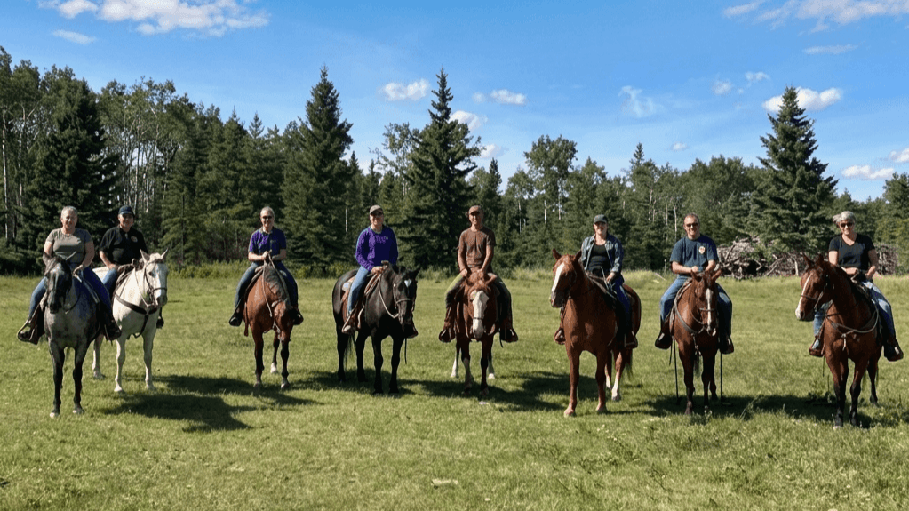 group-of-riders-on-horses Group of people on horseback lined up in a grassy field.